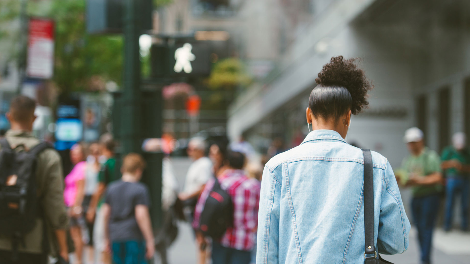 Young woman crossing busy street blurred pedestrians in the background