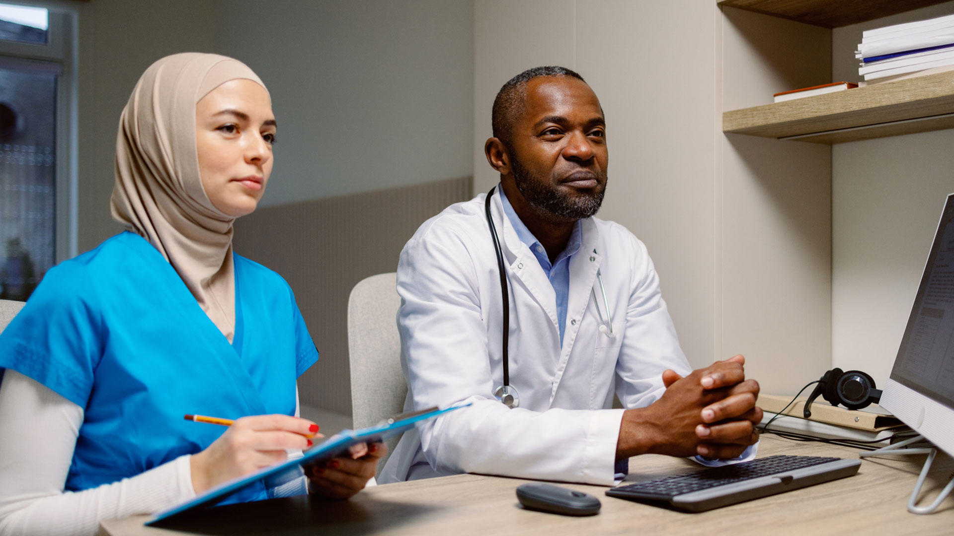 a male and female scientist in white lab coat in a laboratory collaborating