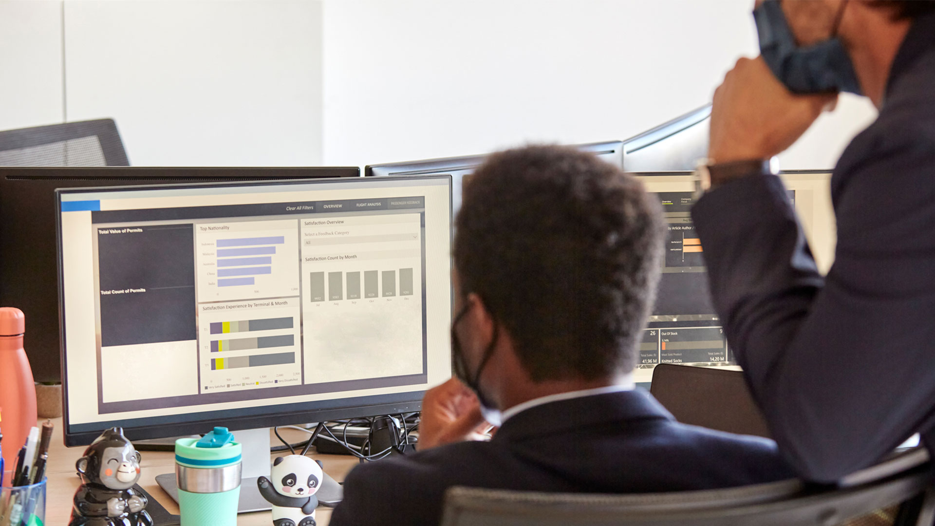 back view of two male collogues reviewing data on a computer together